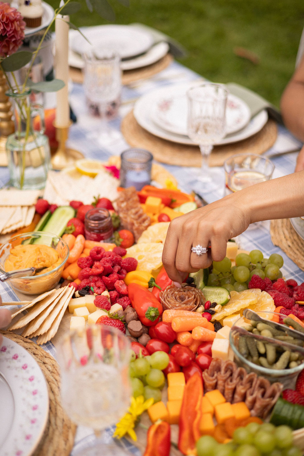 A grazing spread of berries, peppers, cheese and charcuterie on a picnic table at Cathedral Park