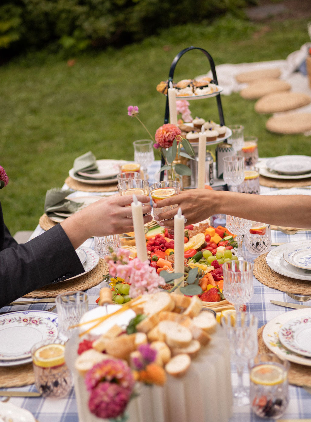 Newlyweds toasting across the picnic table over the grazing spread at Cathedral Park
